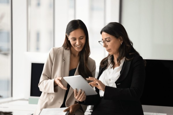 Two screening professionals reviewing information together on a tablet